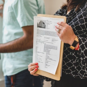 a photo showing somebody holding a printed property listing